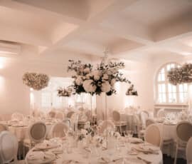 Elegante Hochzeitstischdekoration mit hohen weißen Blumengestecken und schwebender Blumendekoration von Gärtnerei Reinwald Heilbronn.