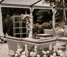 Lounge-Bereich zur Hochzeit mit weißer Blumendekoration, Rosen und grünem Blattwerk von Gärtnerei Reinwald Heilbronn.