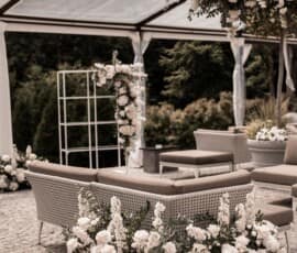 Lounge-Bereich zur Hochzeit mit weißer Blumendekoration, Rosen und grünem Blattwerk von Gärtnerei Reinwald Heilbronn.