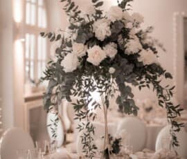 Hohe Hochzeitstischdekoration mit weißen Rosen, Blüten und Eukalyptus von Gärtnerei Reinwald Heilbronn.