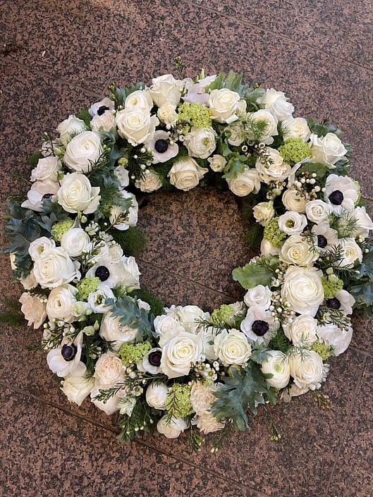 Trauerkranz mit weißen Rosen, Anemonen und frischem Grün – Trauerfloristik der Gärtnerei Reinwald in Heilbronn